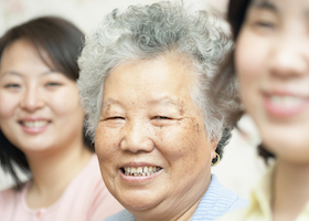 Elderly woman smiling at camera. Vertically framed shot.