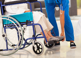 young caregiver helping elderly woman on wheelchair