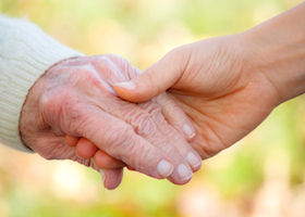 Senior And Young Holding Hands