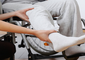 Young physiotherapist exercising with elder disabled person