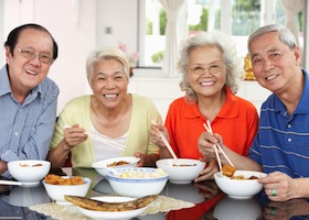 Group Of Senior Chinese Friends Eating Meal At Home