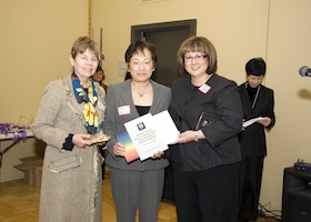 women poses after receiving an award