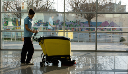 A worker is cleaning the floor with machine