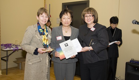 women taking a picture with an award at hand