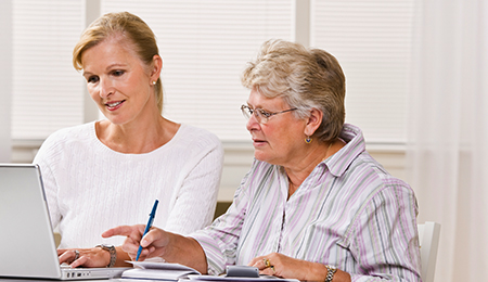 Caregiver helping elderly women on the computer